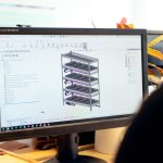 Close-up of an engineer using CAD software for vertical farm design on a desktop computer.
