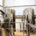 A view of stainless steel tanks in a modern brewery, showcasing industrial machinery and production equipment.