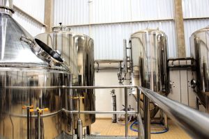 A view of stainless steel tanks in a modern brewery, showcasing industrial machinery and production equipment.